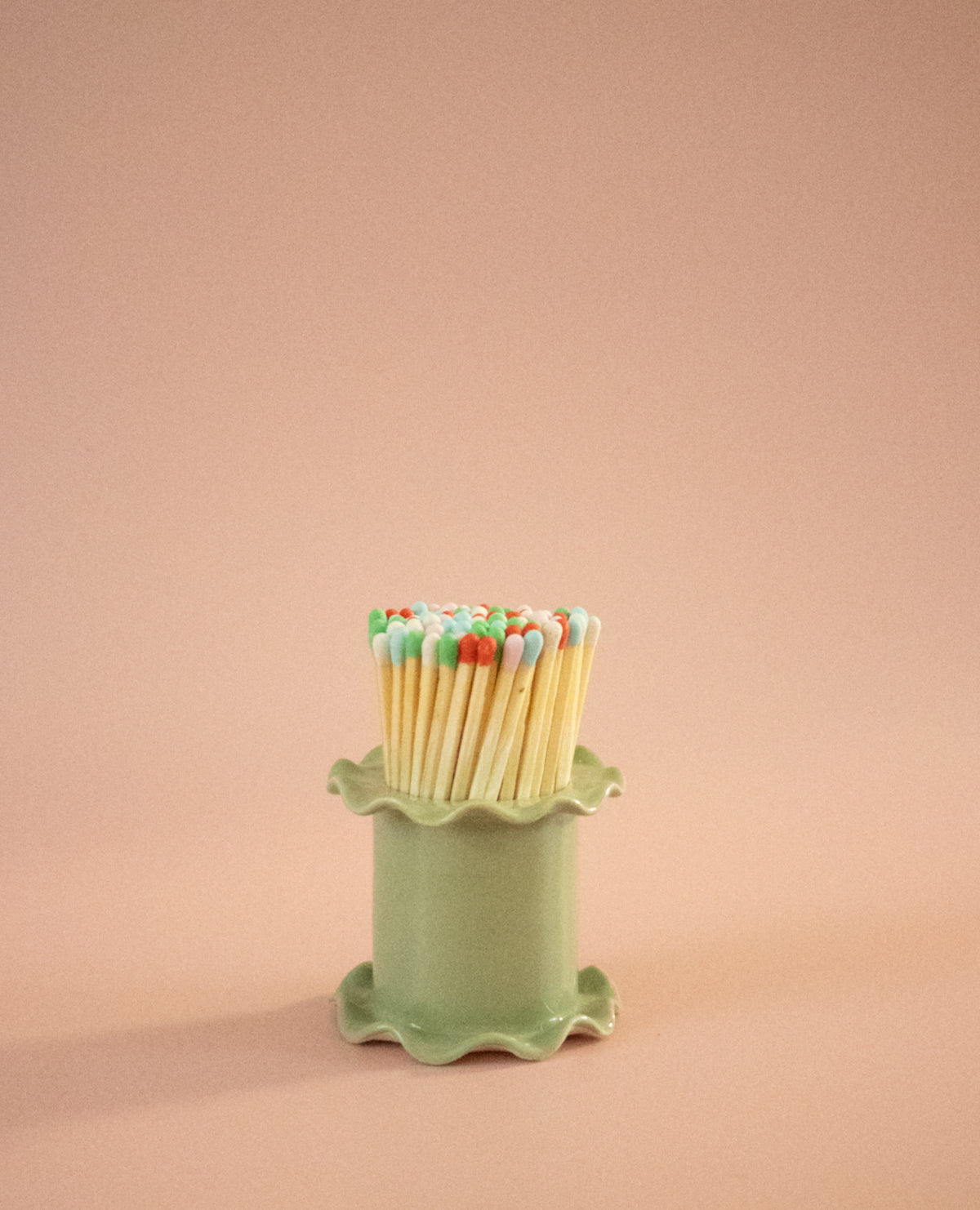 Superfluities frilly-edged ceramic matchstick holder in pistachio green, filled with long matches