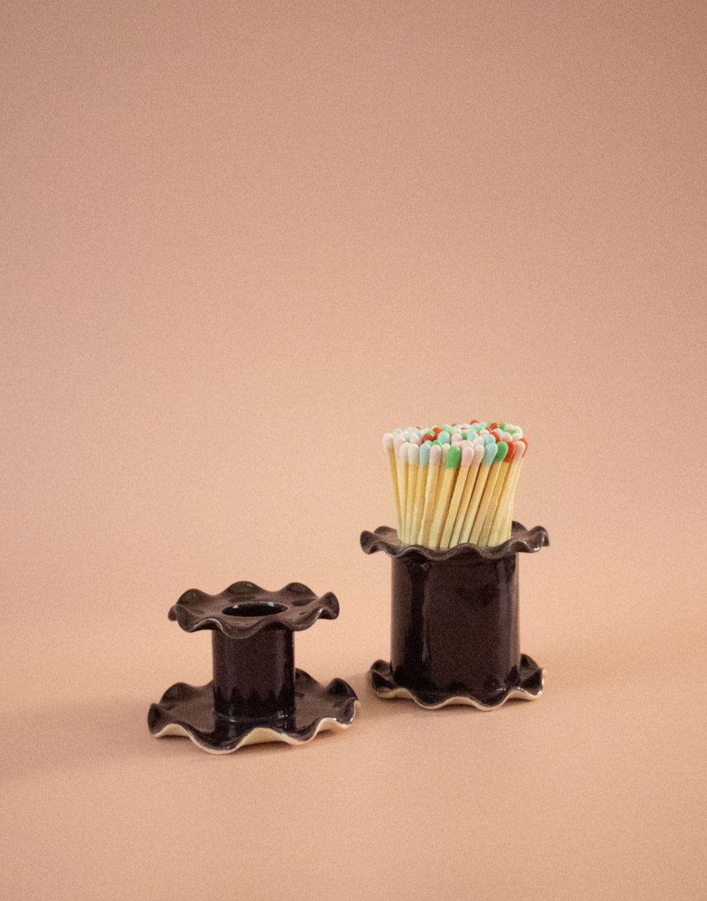 Superfluities frilly-edged ceramic matchstick holder in fig purple, filled with long matches