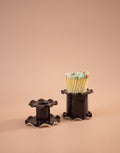 Superfluities frilly-edged ceramic matchstick holder in fig purple, filled with long matches